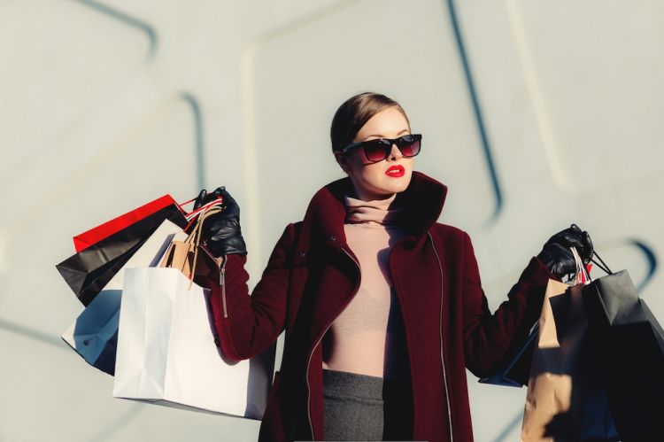 a woman holding several paper shopping bags