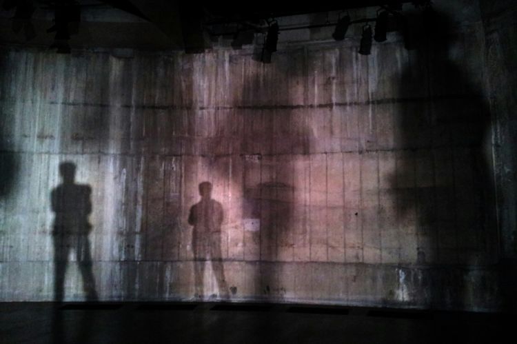 A wall with several human shadows reflected on it.