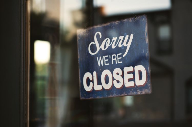 a business sign that says "Sorry, we're closed"