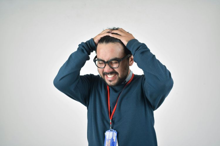 A man holding his head in a stressed way