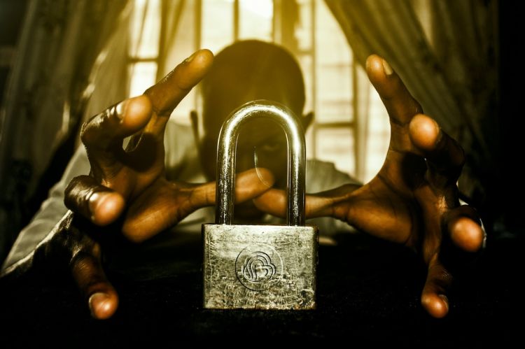 a person holding a padlock in front of a window
