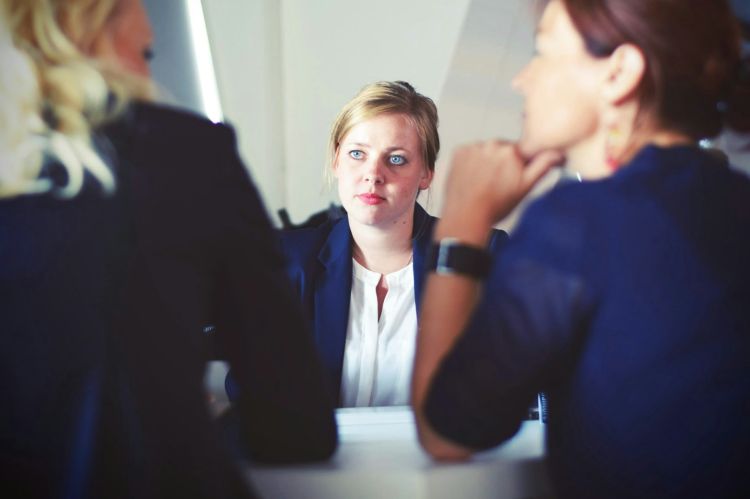 Three businesswomen sitting at a table.