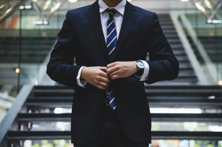 a man buttoning his suit jacket