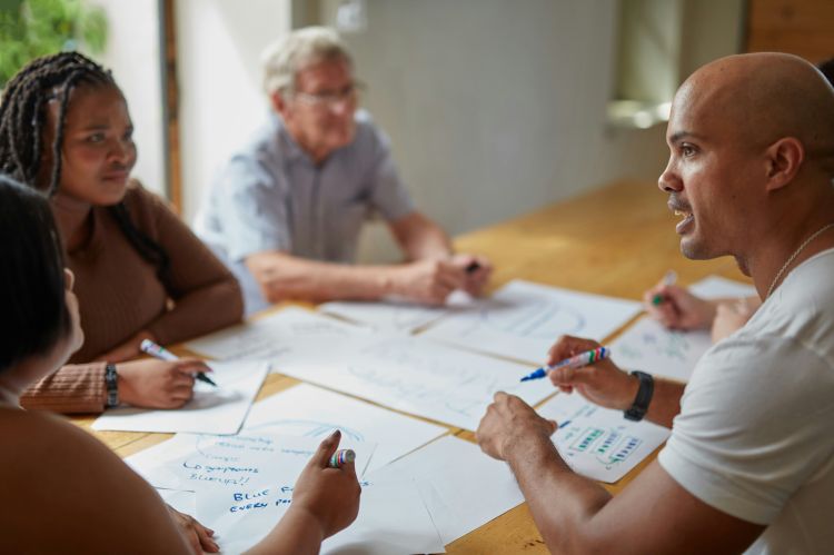people sitting around a conference table writing on papers