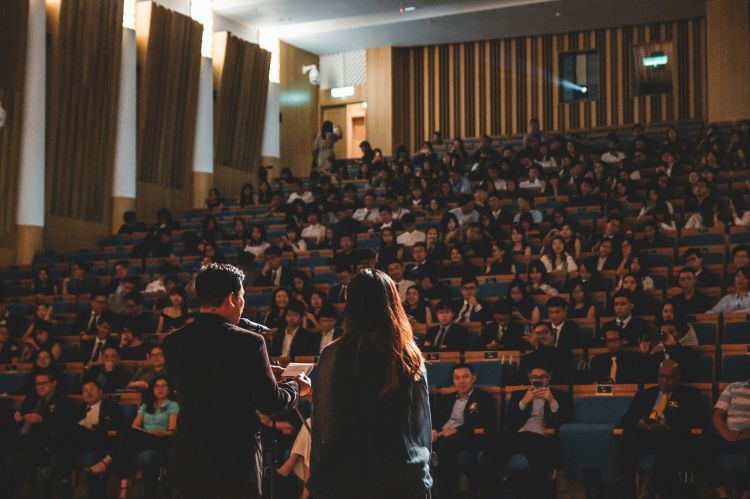two people giving a presentation on a stage in front of an audience