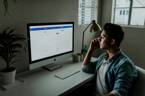 a man sitting at a desk making a phone call