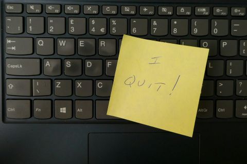 Closeup of a keyboard covered with a post-it note reading "I quit!"