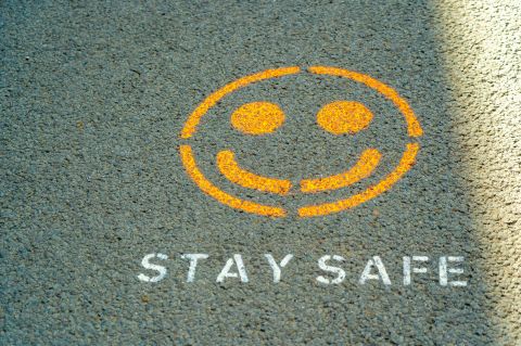 The words "Stay Safe" and a smiley face painted on the ground.