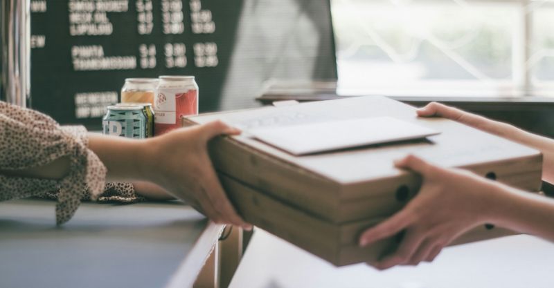person handing over a stack of papers to another person