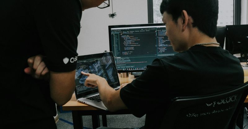 Two men working on a computer in an office