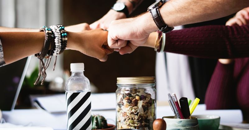 Diverse group of people fist bumping over desk. Free for use under the Pixabay Content License