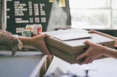 person handing over a stack of papers to another person