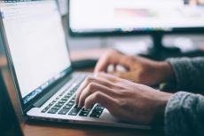 Closeup of a person typing on a laptop keyboard.