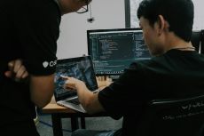 Two men working on a computer in an office