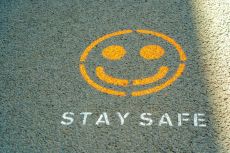 The words "Stay Safe" and a smiley face painted on the ground.