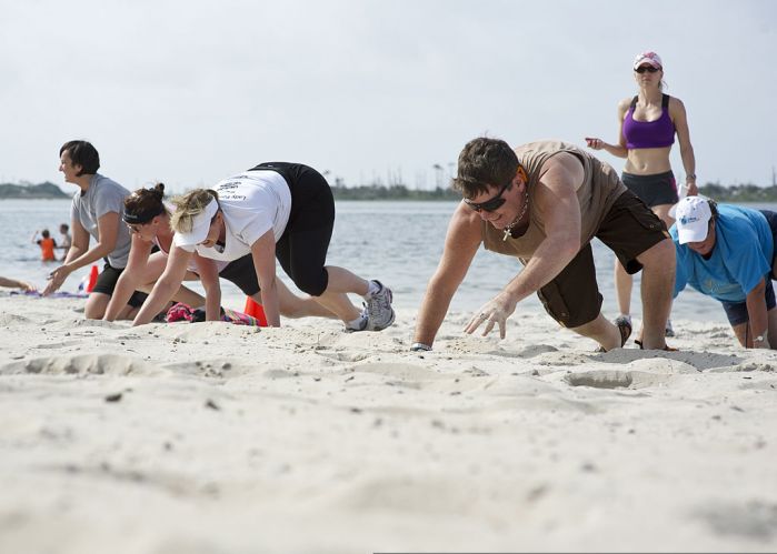 Participants of a beach boot camp class crawl across Soundside Beach at Hurlburt Field, Fla., May 18, 2013. The class combined a number of physical challenges and obstacles designed to push people past their physical limits.